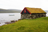 Sørvagsvatn lake, Vágar island, Faroes: small stone house with sod roof on the lake shore - torvtak - photo by A.Ferrari