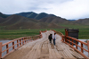 Khövsgöl province, Mongolia: young boy leading his horse on an old bridge, on the way to Mörön - photo by A.Ferrari
