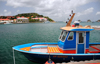 Gustavia, St. Barts / Saint-Barthélemy: blue boat in the harbour - Fort Oscar, museum and Hôtel de la Collectivité  in the background - photo by M.Torres